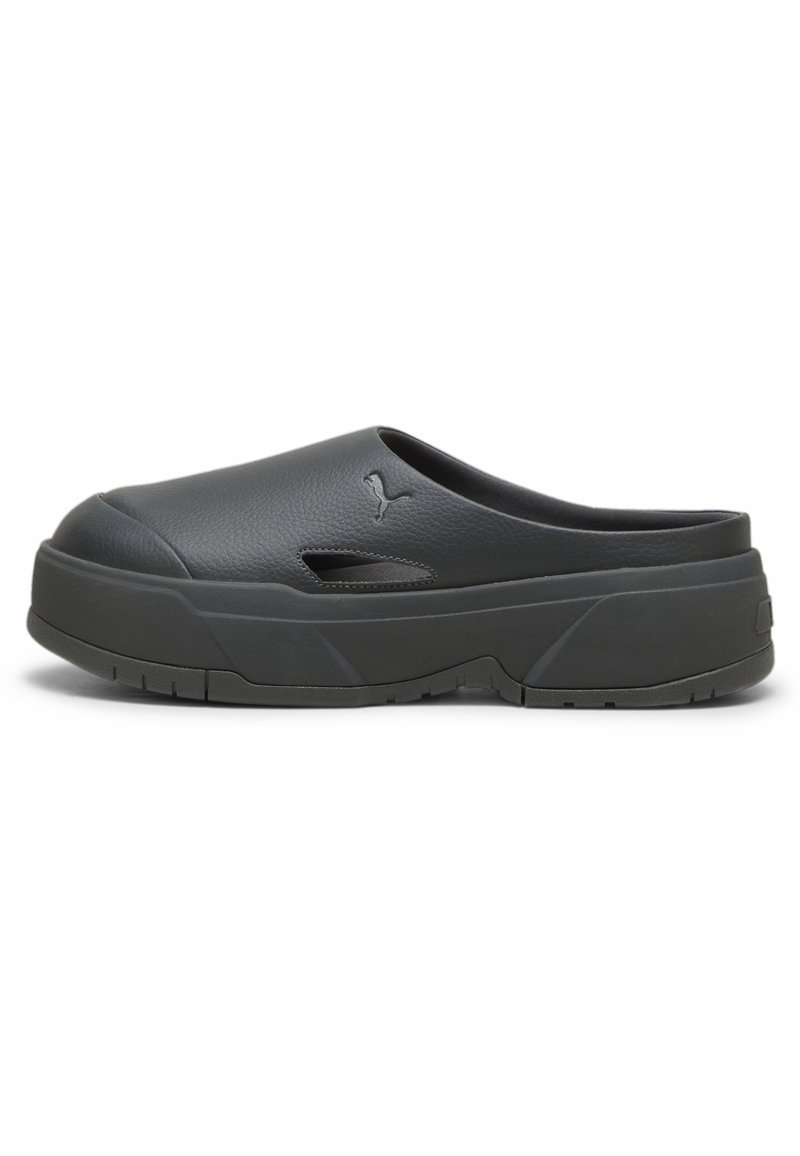 Sabot noir à enfiler avec une semelle épaisse, une petite ventilation latérale et le logo Puma sur le dessus, conçu pour un usage décontracté.