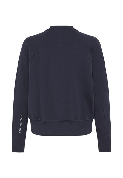 Tamsiai mėlynas džemperis su apvalia iškirpte, raglan rankovėmis, gomuriais ant rankovių ir hemu, su baltais tekstiniais akcentais kairėje rankovėje.