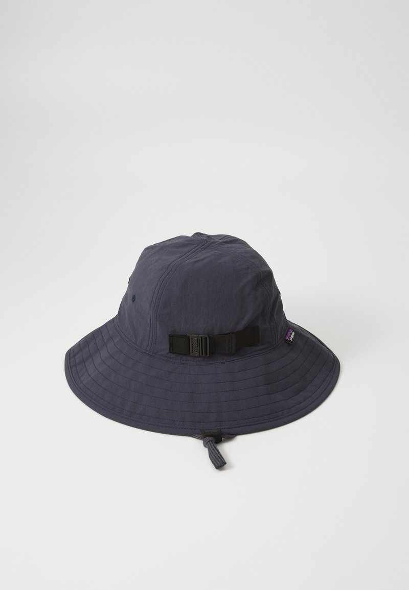 Chapéu balde azul-marinho feito de tecido macio, com uma aba larga, cinta ajustável e um detalhe de costura discreto.