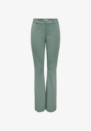 Pantalon évasé vert à la texture lisse. Il présente un devant plat, des passants pour ceinture et une fermeture éclair dissimulée à la taille.