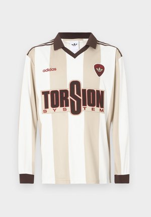 Beige en wit gestreept voetbalshirt met lange mouwen; heeft een bruine kraag en manchetten, een groot rood "TORSION SYSTEM" logo en adidas branding.