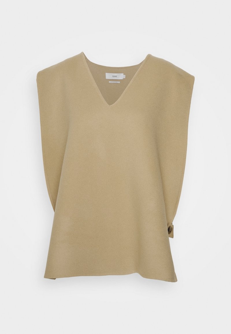 Gilet beige sans manches en maille avec col en V, épaules matelassées et détail de boutons sur un côté, présenté sur un fond blanc.