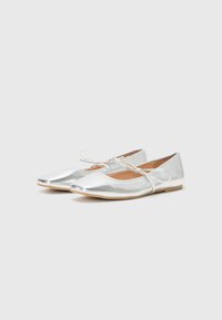 Silver metallic ballet flats with a pointed toe, featuring a thin strap across the instep and a flat, textured sole.
