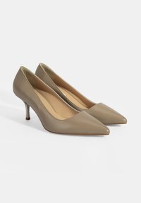 Talons aiguilles en cuir beige avec une pointe effilée et un talon fin métallique. Texture lisse et design minimaliste.