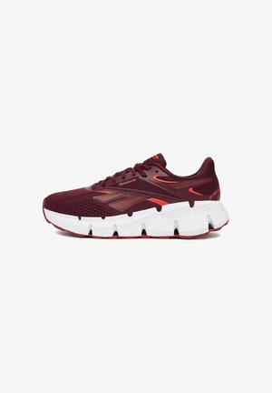 Zapatilla de correr Reebok en rojo oscuro con parte superior de malla, mediasuela blanca y suela exterior de goma texturizada. Presenta una marca visible y cordones.