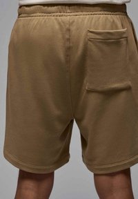 Bermuda khaki con vita elastica, tasche laterali e tasca a toppa sul retro; realizzate in un morbido tessuto testurizzato.