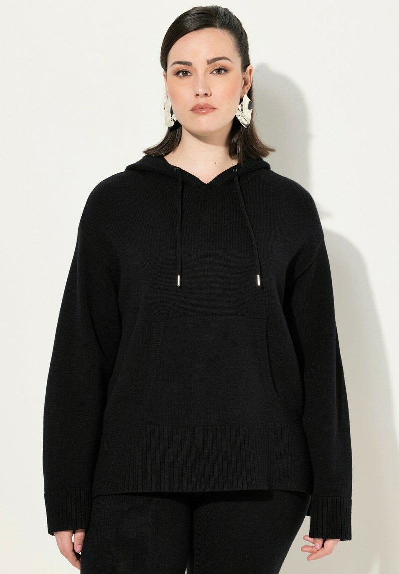 Felpa nera con cappuccio in tessuto testurizzato, dotata di tasca frontale, orlo a coste e stringhe regolabili con punte metalliche.