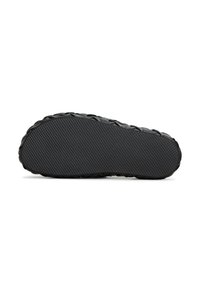 Sole di scarpa nera con una finitura in gomma testurizzata, caratterizzata da un design con bordo intrecciato e un motivo scanalato antiscivolo per una migliore aderenza.