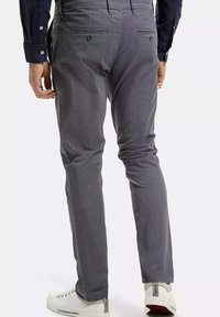 Szare spodnie w wzory o dopasowanym kroju, z tylnymi kieszeniami i gładką fakturą, w połączeniu z białymi sneakersami.