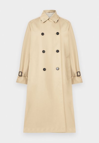 Trench-coat beige croisé avec boutons noirs, col, deux poches latérales et sangles à boucle aux manches.