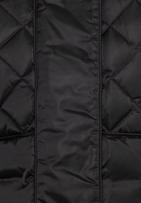 Černá péřová bunda s prošívaným designem ve tvaru diamantů a hladkým, lesklým materiálem. Obsahuje prošité detaily podél švů.