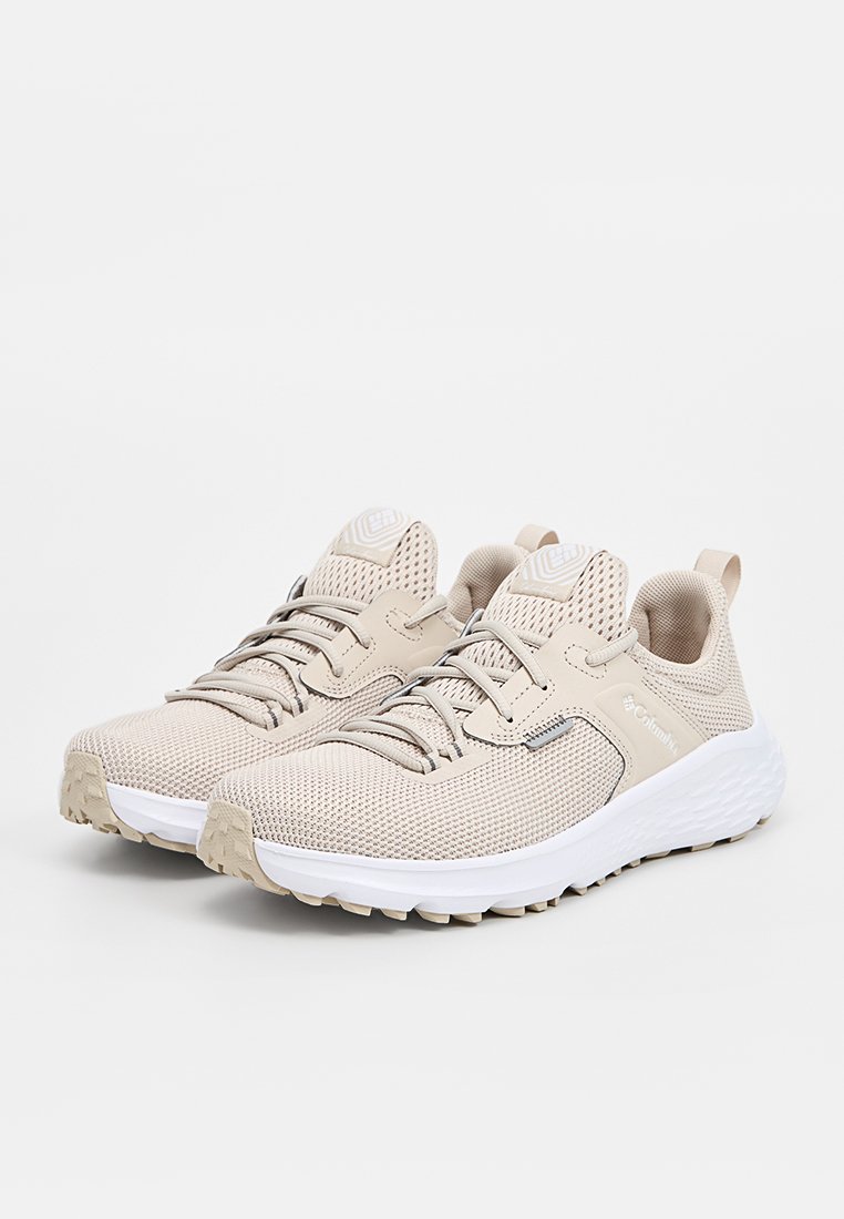 Zapatillas deportivas de color beige claro con parte superior de malla transpirable, diseño texturizado y suela de goma blanca. Cuenta con cierre de cordones y detalle de logo.