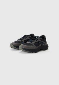 Black and gray sneakers featuring a mesh upper, padded collar, rubber sole, and tonal “HUGO” branding on the side. Low-profile design.