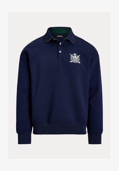 Πουλόβερ σε ναυτικό μπλε με γιακά, λευκό κεντημένο λογότυπο και πράσινο εσωτερικό γιακά. Κατασκευασμένο από μαλακό ύφασμα με ριμπ μανσέτες.