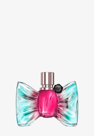 Perfume bottle shaped like a bow with translucent turquoise wings and a central bright pink body, topped with a metallic cap and black seal.