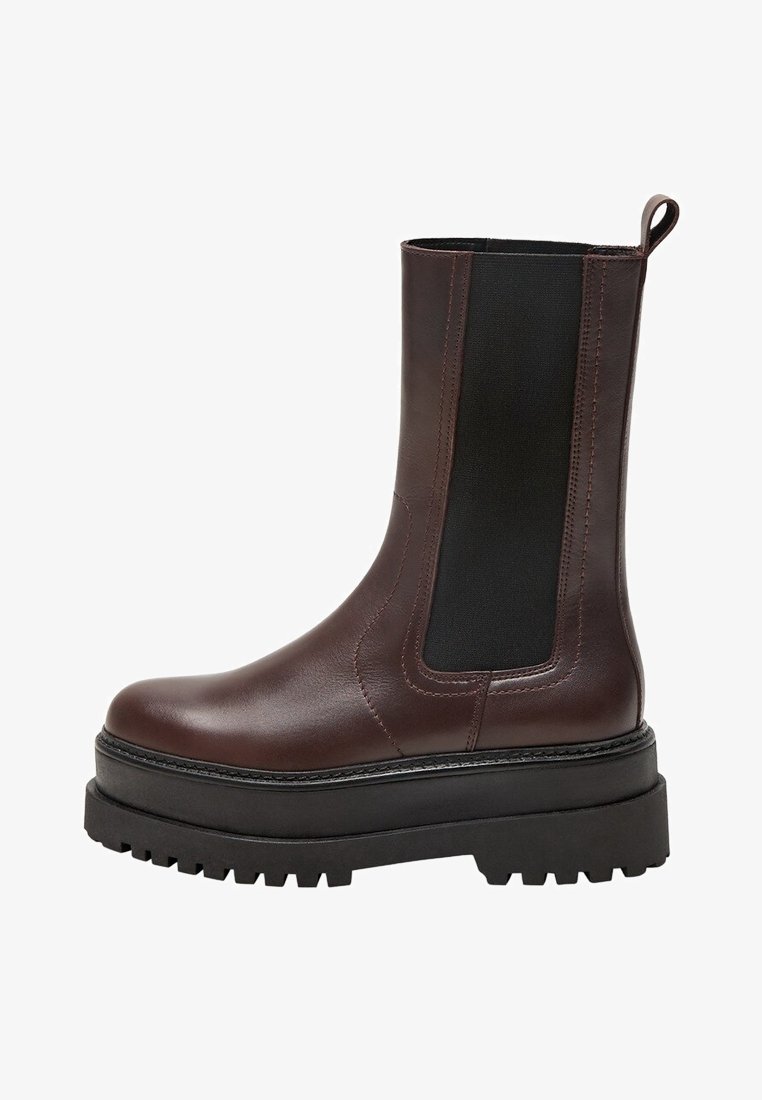 Bottines en cuir marron avec panneaux élastiques noirs sur les côtés, semelle noire épaisse et languette. Présente une texture lisse et un design à bout rond.