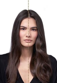 Portrait d'une personne avec de longs cheveux brun foncé, de face, présentant un teint doux et lisse ainsi que des traits symétriques, portant un haut noir.