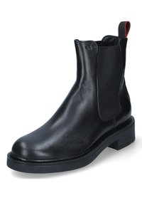 Stivale Chelsea in pelle nera con pannelli laterali elasticizzati, punta rotonda e suola spessa. Presenta una linguetta con accento rosso nella parte superiore.