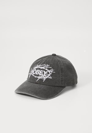 Black cotton cap with a curved brim, featuring white embroidered "OBEY" logo and abstract design. Structured top with ventilation holes.