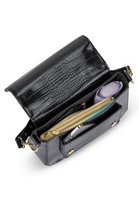 Black leather handbag with crocodile texture, golden zipper detail, and multiple compartments. Open showing interior items, including an umbrella.