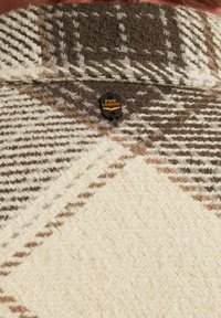 Wollen blend jas met een visgraatpatroon in beige en bruintinten, met een zwarte label met de tekst "PME LEGEND" bij de kraag.