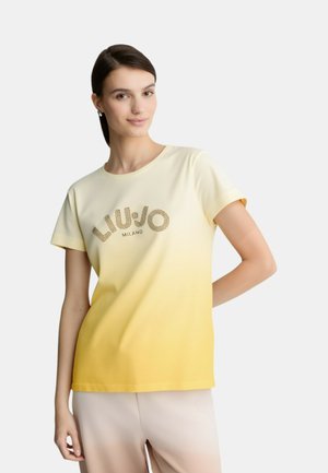 T-shirt con gradiente giallo e crema, con scollatura rotonda, maniche corte e logo "LIU JO MILANO" decorato con strass. Texture del tessuto liscia.