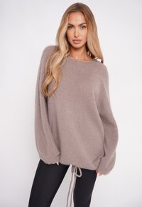 Przesadny sweter w kolorze miękkiego taupe, z okrągłym dekoltem, opadającymi ramionami oraz regulowanym ściągaczem u dołu. Gładka faktura.