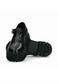 Scarpe Mary Jane in pelle nera con suola in gomma spessa, dotate di una tracolla con fibbia e punta arrotondata. La suola esterna presenta un motivo di presa testurizzato.
