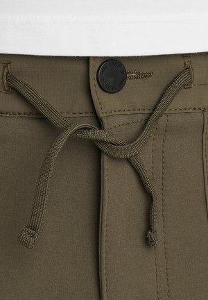 Olive green pants with a textured fabric, featuring a drawstring and a round black logo button at the waist for secure fastening.
