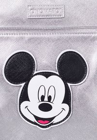 Zaino metallizzato argento con una grande toppa del volto di Topolino in bianco e nero, con orecchie nere e una lingua rosa.