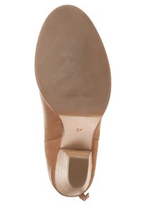 Zapato de cuero marrón con puntera redondeada, tacón apilado, suela texturada y marca de tamaño (37). Parte superior lisa con detalles de costura mínimos.