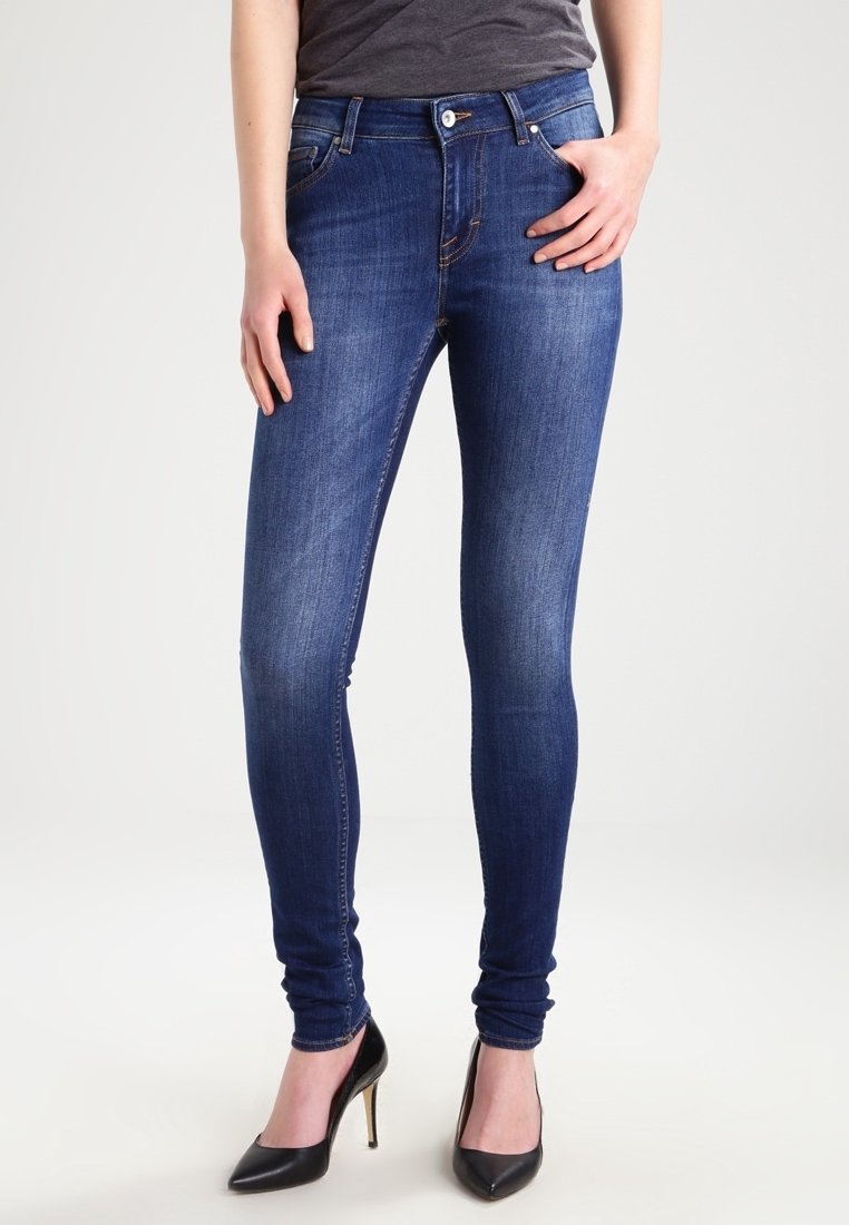 Smaljeans i mörkblå denim med en slät textur, med en medelhög midja, femfickorsdesign och kontrasterande stickningar.