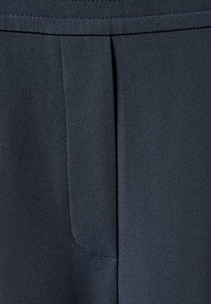 Donkerblauwe stof close-up met een gladde textuur, voorzien van een enkele plooi en fijn gestikte naden.