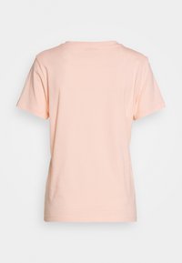 Lys rosa kortærmet bomulds T-shirt vist fra ryggen på en neutral baggrund.