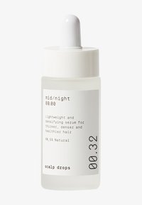 Bouteille en verre transparent avec bouchon blanc et compte-gouttes. L'étiquette comporte un texte noir. Décrit comme un sérum léger pour des cheveux plus épais et plus sains.