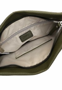 Innenseite einer olivgrünen Lederhandtasche mit einem beigen Stofffutter, einer Reißverschlusstasche und einem Patch mit eingeprägter Aufschrift "RUD_09". Weiche Textur und langlebiges Design.
