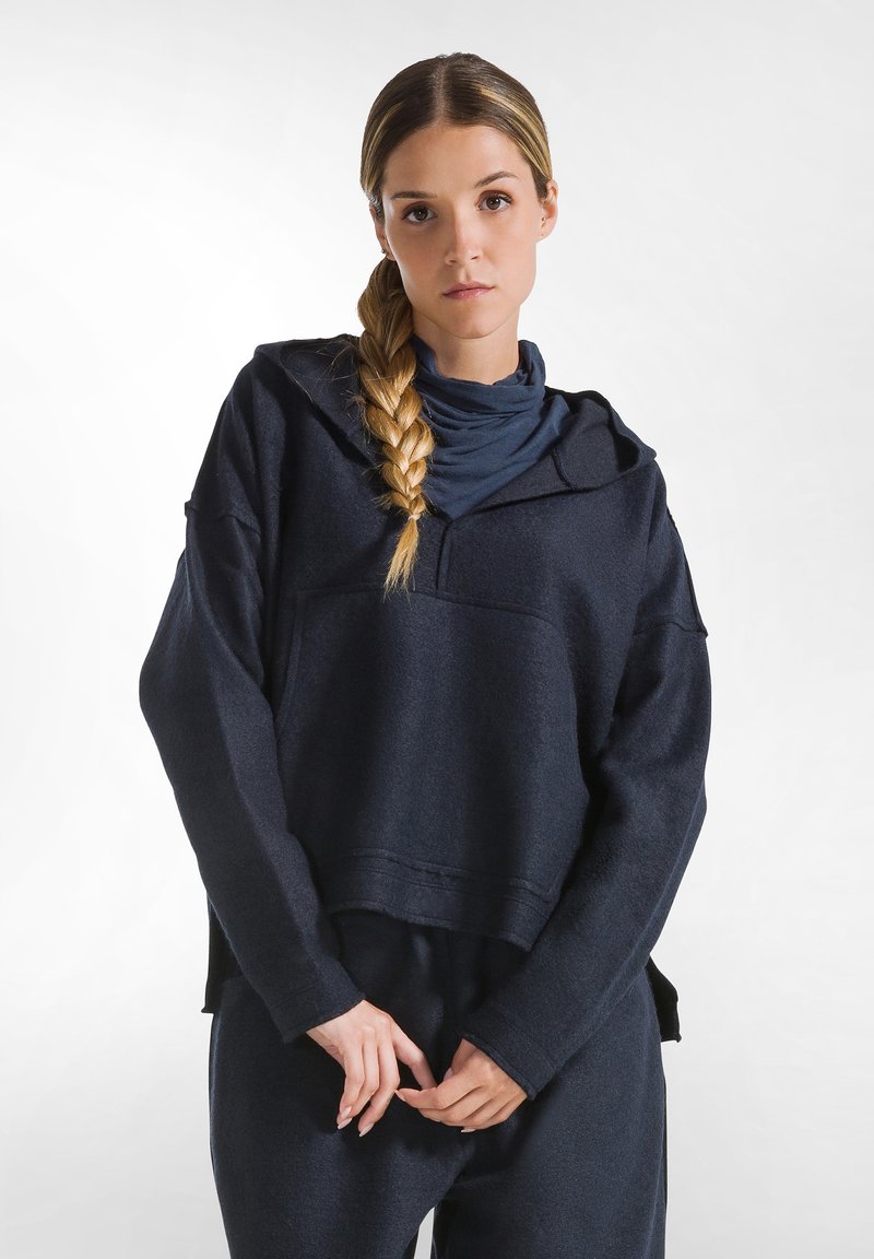 Mörkblå, texturerad sweatshirt med huva och en framficka. Har en lös passform och lång ärm, i kombination med matchande byxor.