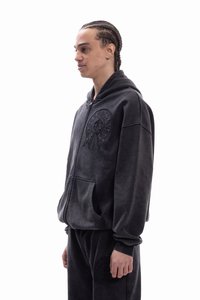 Φούτερ με κουκούλα από βελούδο σκούρου γκρι, με μεγάλο ανάγλυφο λογότυπο στο στήθος, μπροστινές τσέπες και χαλαρή εφαρμογή.