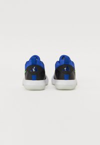 Black and blue athletic shoes with a textured upper, padded collar, and white sole, featuring a logo and a green accent on the heel.
