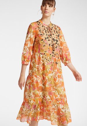 Bloemendress met levendige oranje, roze en groene prints, van een licht, vloeiend materiaal, met driekwart mouwen en een gelaagde zoom.