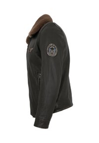 Black leather bomber jacket with a brown shearling collar. Features a side zipper and patches on the left sleeve. Smooth texture.