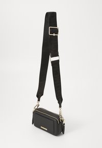 Borsa a tracolla nera in ecopelle con chiusura a zip, caratterizzata da dettagli in oro e da una tracolla regolabile con logo.