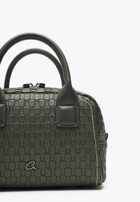 Borsa a mano grigia intrecciata con manici tondi, dotata di una superficie testurizzata e dettagli di cucitura bianca. Include una chiusura con zip e un logo.