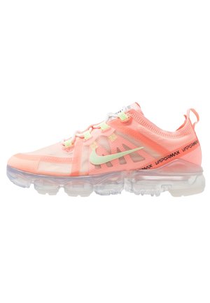 Koraalroze Nike Vapormax sneaker met transparante luchtkussenzool, lichtgroene swoosh, witte veters en zwarte "Vapormax"-tekst op de hielband.