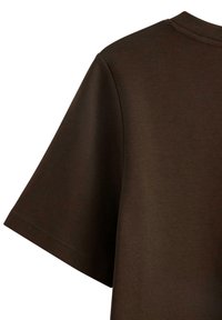 Mørkebrun kortærmet T-shirt med synlige syninger på ærmet og skuldersømmen mod en hvid baggrund.