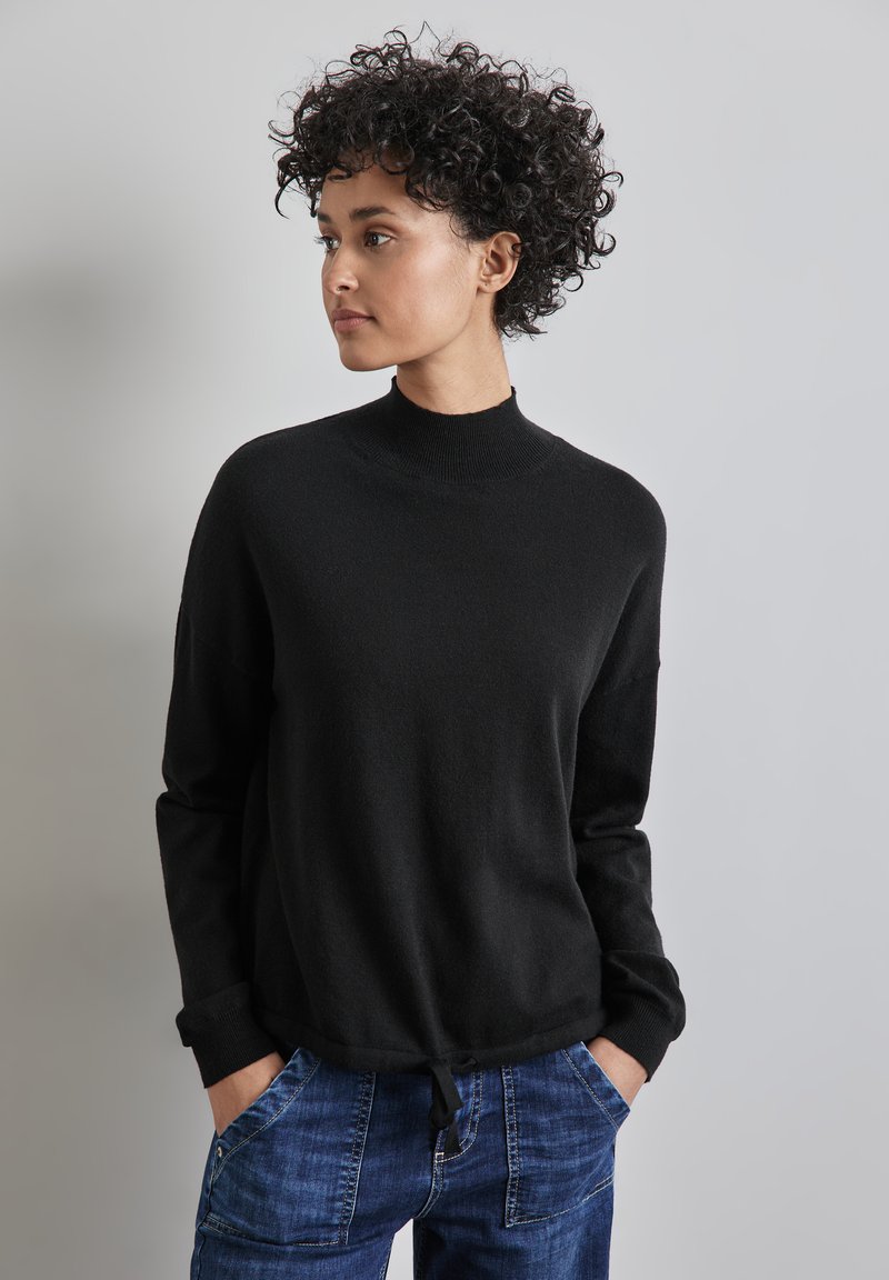 Schwarzer gestrickter Pullover mit hohem Kragen, langen Ärmeln und Kordelzugsaum. Der Stoff wirkt weich und hat eine leicht lockere Passform.