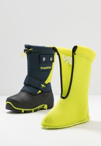 Blaue und gelbe wasserdichte Winterstiefel mit einem weichen Fleece-Futter, verstellbarem Riemen und Gummisohle für Traktion. Hat ein zweifarbigen Design.