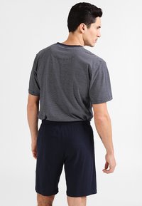 Ensemble de vêtements d'intérieur pour hommes comprenant un haut à manches courtes rayé bleu marine et un short bleu marine uni, fabriqué en tissu doux avec une taille élastique.