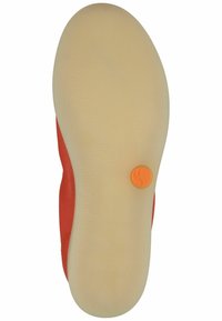 Suola di una scarpa, con una superficie cremosa texturizzata e un accento arancione circolare. Il lato è in pelle rossa, con un design curvo e una decorazione minimale.