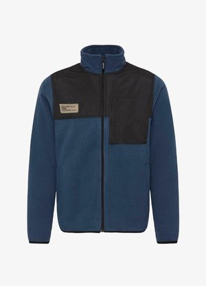 Sötétkék polárdzseki fekete panelek, magas gallér, teljes cipzár és elülső mellzseb jellemzi. A bal felső oldalon címke található.